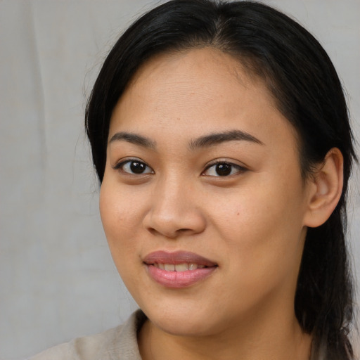 Joyful asian young-adult female with long  brown hair and brown eyes
