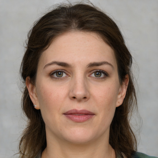 Joyful white adult female with medium  brown hair and green eyes