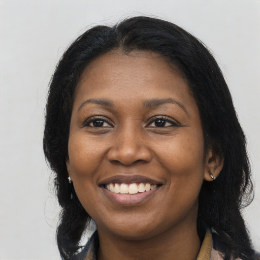 Joyful black young-adult female with long  brown hair and brown eyes