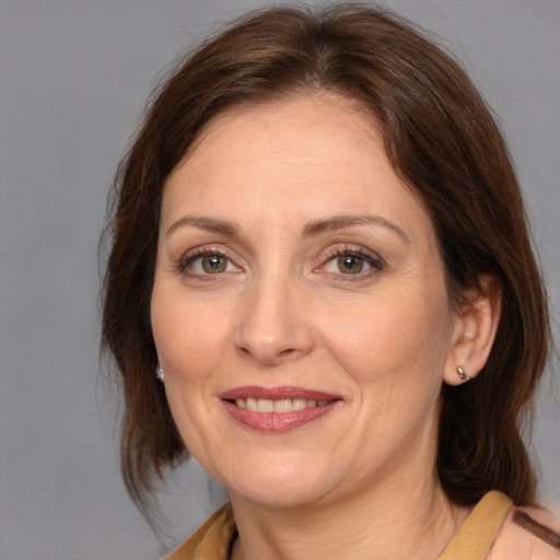 Joyful white adult female with medium  brown hair and brown eyes