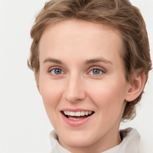 Joyful white young-adult female with short  brown hair and green eyes