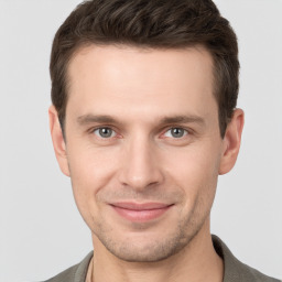 Joyful white young-adult male with short  brown hair and grey eyes