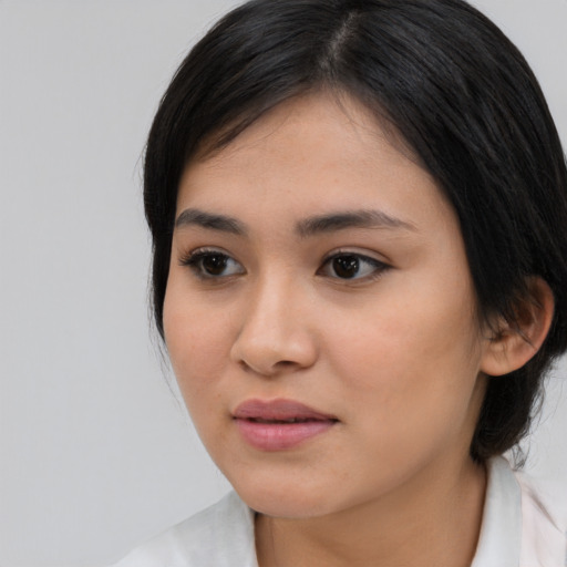 Joyful asian young-adult female with medium  brown hair and brown eyes
