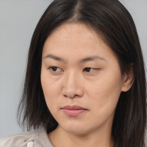 Joyful asian young-adult female with long  brown hair and brown eyes