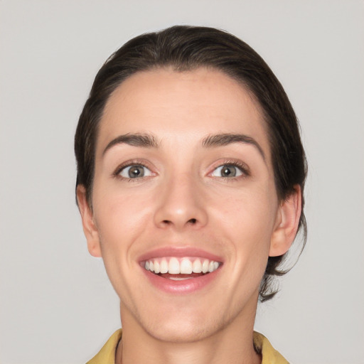 Joyful white young-adult female with short  brown hair and grey eyes