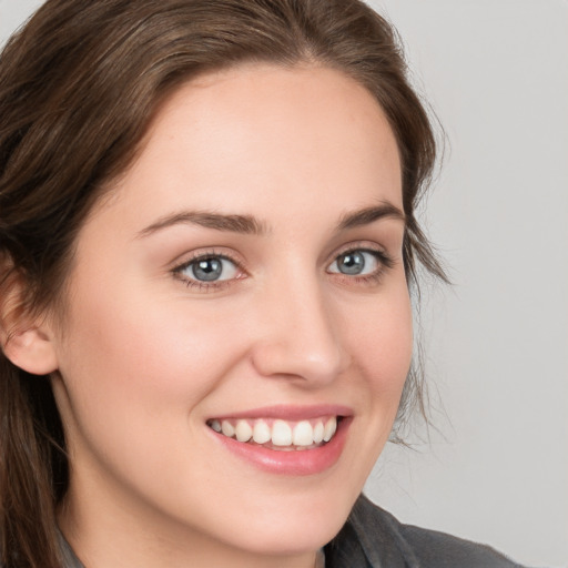 Joyful white young-adult female with long  brown hair and grey eyes