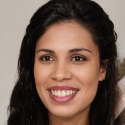 Joyful latino young-adult female with long  brown hair and brown eyes