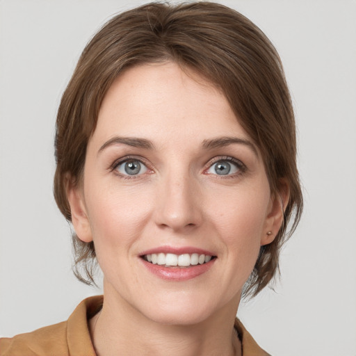 Joyful white young-adult female with medium  brown hair and grey eyes