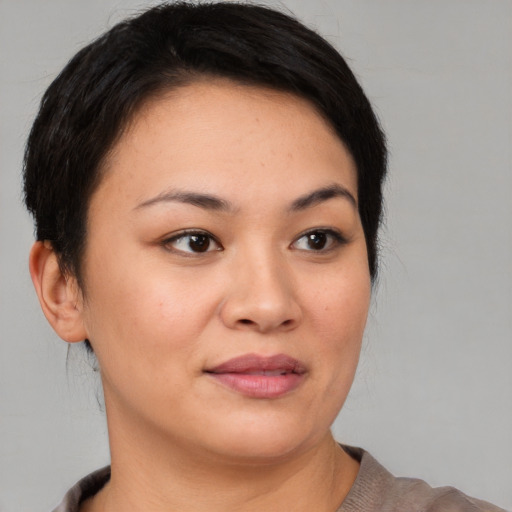 Joyful asian young-adult female with short  brown hair and brown eyes