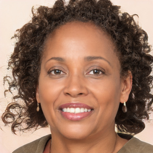 Joyful black adult female with medium  brown hair and brown eyes