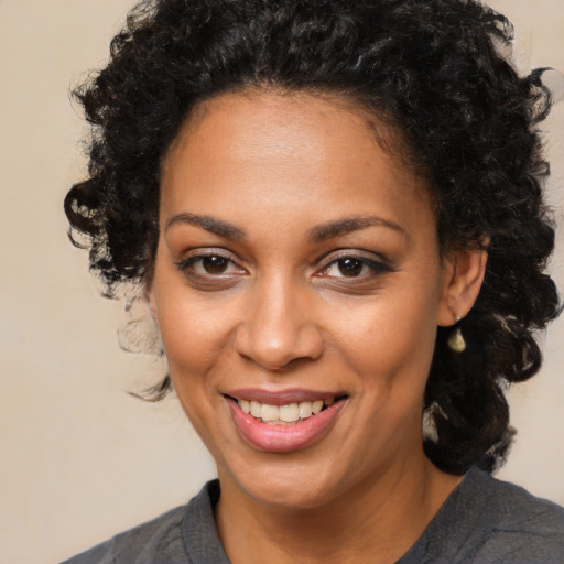 Joyful black young-adult female with medium  brown hair and brown eyes