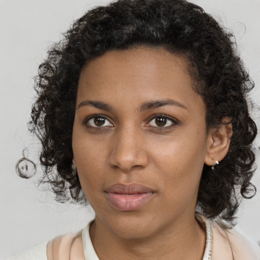 Joyful black young-adult female with medium  brown hair and brown eyes