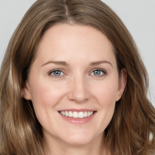 Joyful white young-adult female with long  brown hair and grey eyes