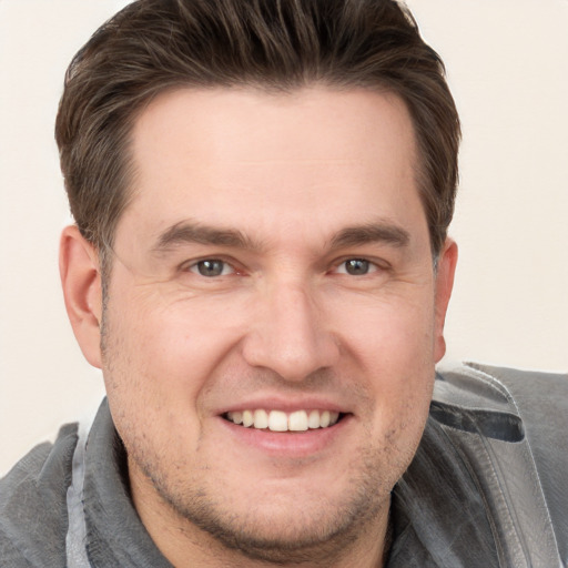 Joyful white adult male with short  brown hair and grey eyes