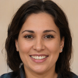 Joyful white adult female with long  brown hair and brown eyes