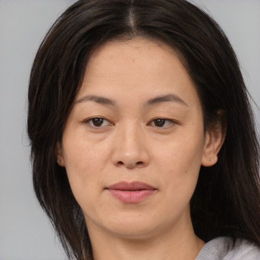 Joyful asian adult female with medium  brown hair and brown eyes