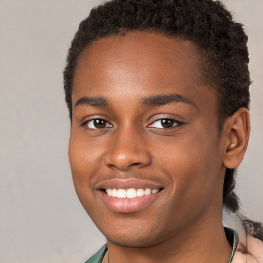 Joyful black young-adult male with short  brown hair and brown eyes