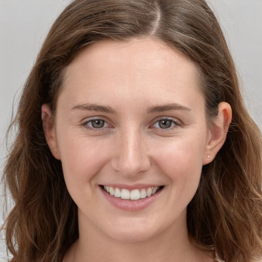 Joyful white young-adult female with long  brown hair and grey eyes