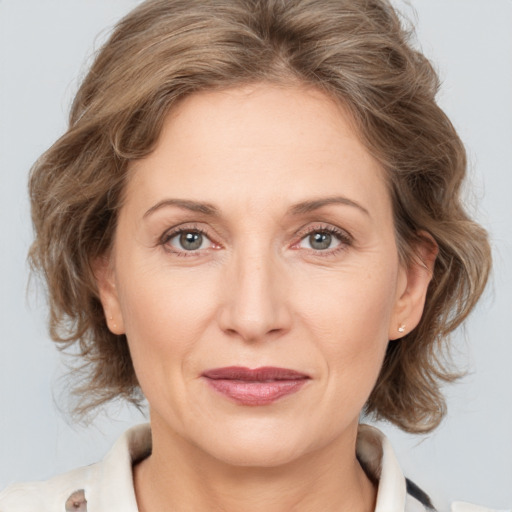 Joyful white adult female with medium  brown hair and grey eyes