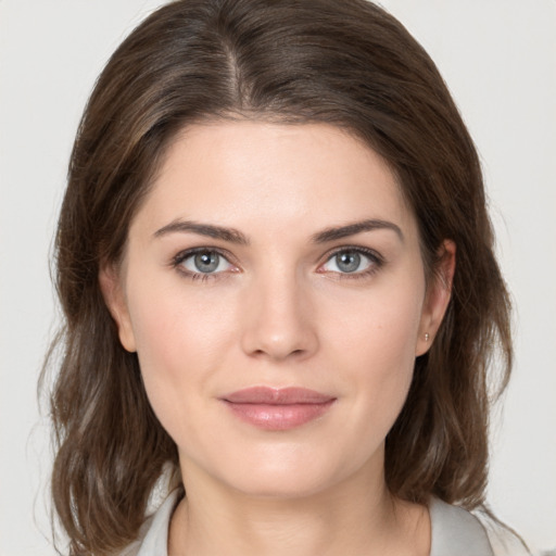 Joyful white young-adult female with medium  brown hair and grey eyes