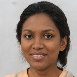 Joyful black young-adult female with medium  brown hair and brown eyes