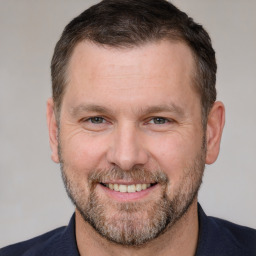 Joyful white adult male with short  brown hair and brown eyes