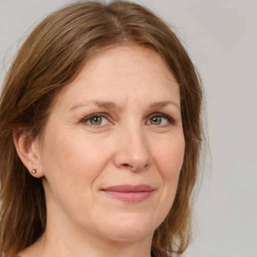 Joyful white adult female with medium  brown hair and green eyes