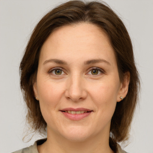 Joyful white adult female with medium  brown hair and green eyes