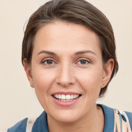 Joyful white young-adult female with short  brown hair and grey eyes