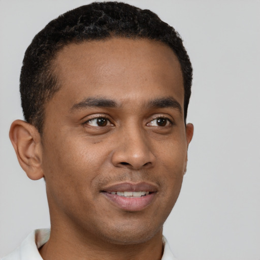 Joyful black young-adult male with short  brown hair and brown eyes