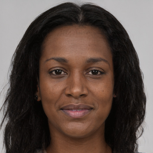 Joyful black young-adult female with long  black hair and brown eyes