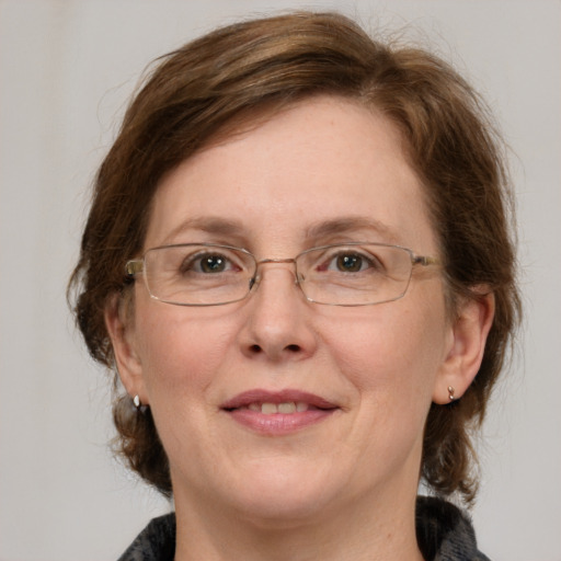 Joyful white adult female with medium  brown hair and green eyes