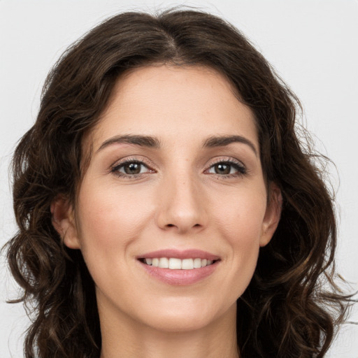 Joyful white young-adult female with long  brown hair and green eyes