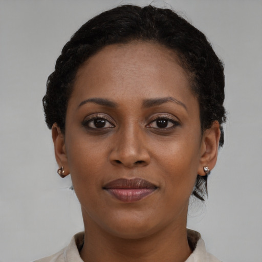 Joyful black young-adult female with short  brown hair and brown eyes