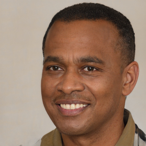 Joyful black young-adult male with short  brown hair and brown eyes