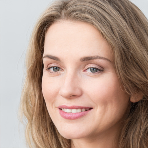 Joyful white young-adult female with long  brown hair and blue eyes