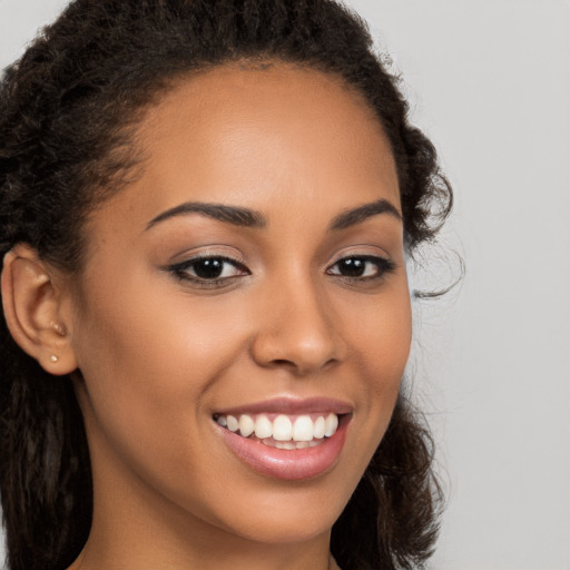 Joyful latino young-adult female with long  brown hair and brown eyes