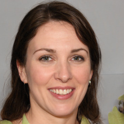 Joyful white young-adult female with medium  brown hair and green eyes