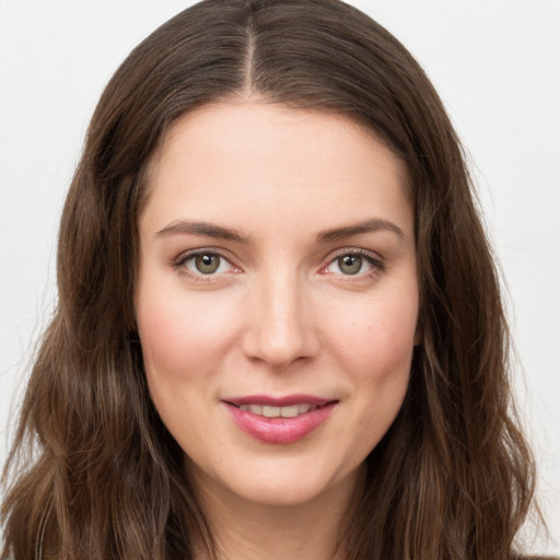 Joyful white young-adult female with long  brown hair and green eyes