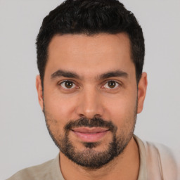 Joyful latino young-adult male with short  black hair and brown eyes