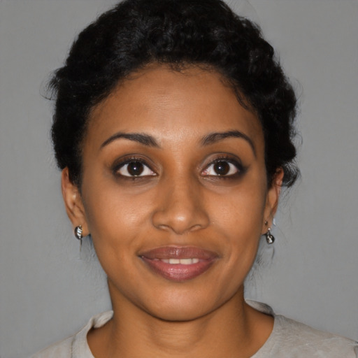 Joyful black young-adult female with short  black hair and brown eyes