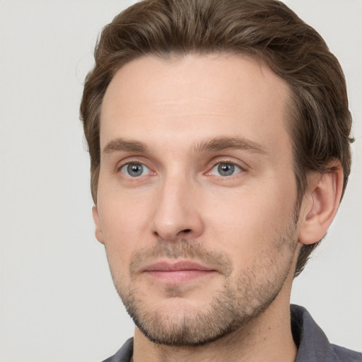 Joyful white young-adult male with short  brown hair and grey eyes