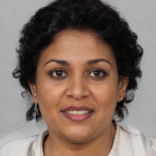 Joyful latino adult female with short  brown hair and brown eyes