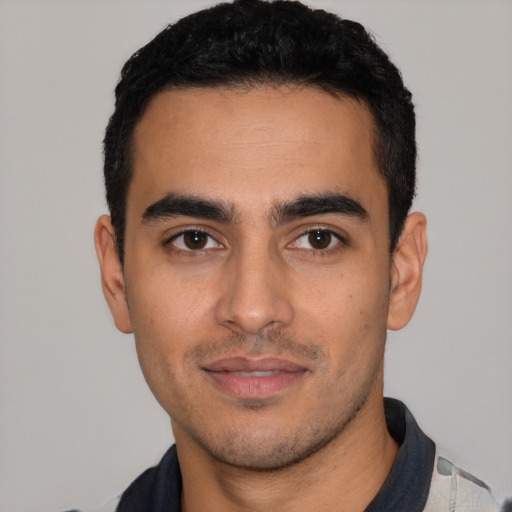 Joyful latino young-adult male with short  black hair and brown eyes