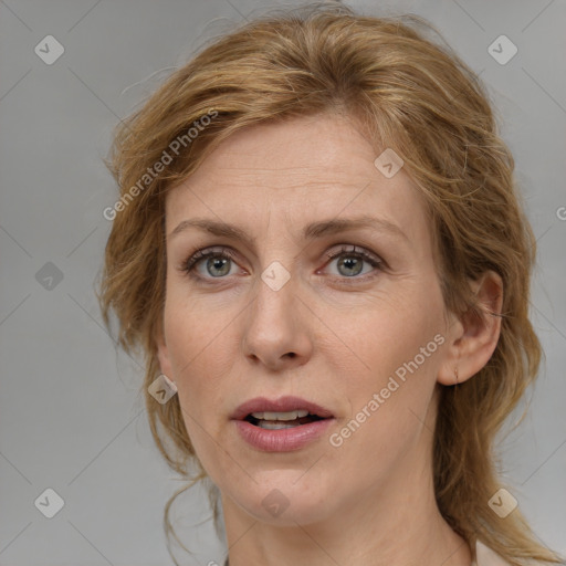 Joyful white adult female with medium  brown hair and blue eyes