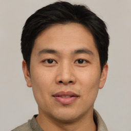 Joyful asian young-adult male with short  brown hair and brown eyes