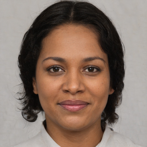 Joyful black young-adult female with medium  brown hair and brown eyes