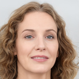 Joyful white young-adult female with long  brown hair and green eyes