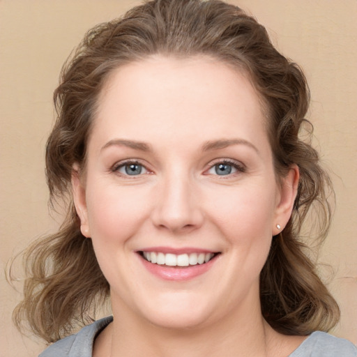 Joyful white young-adult female with medium  brown hair and blue eyes