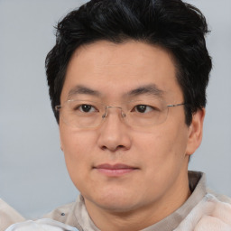 Joyful asian adult male with short  black hair and brown eyes